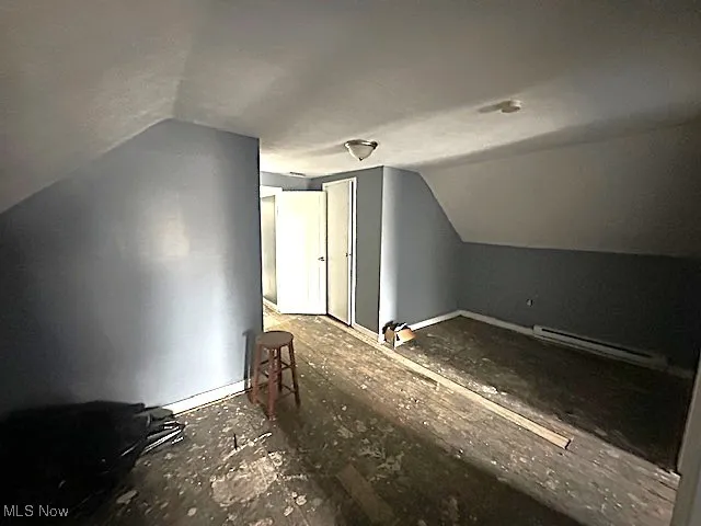 Additional living space featuring lofted ceiling and baseboard heating