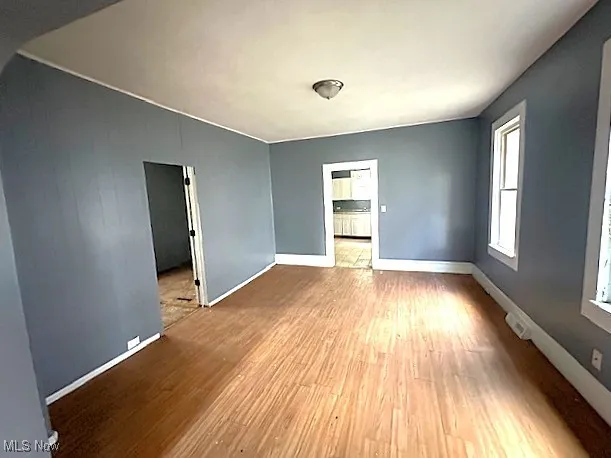 Empty room featuring wood finished floors and baseboards