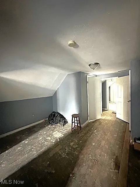 Bonus room featuring vaulted ceiling and baseboards
