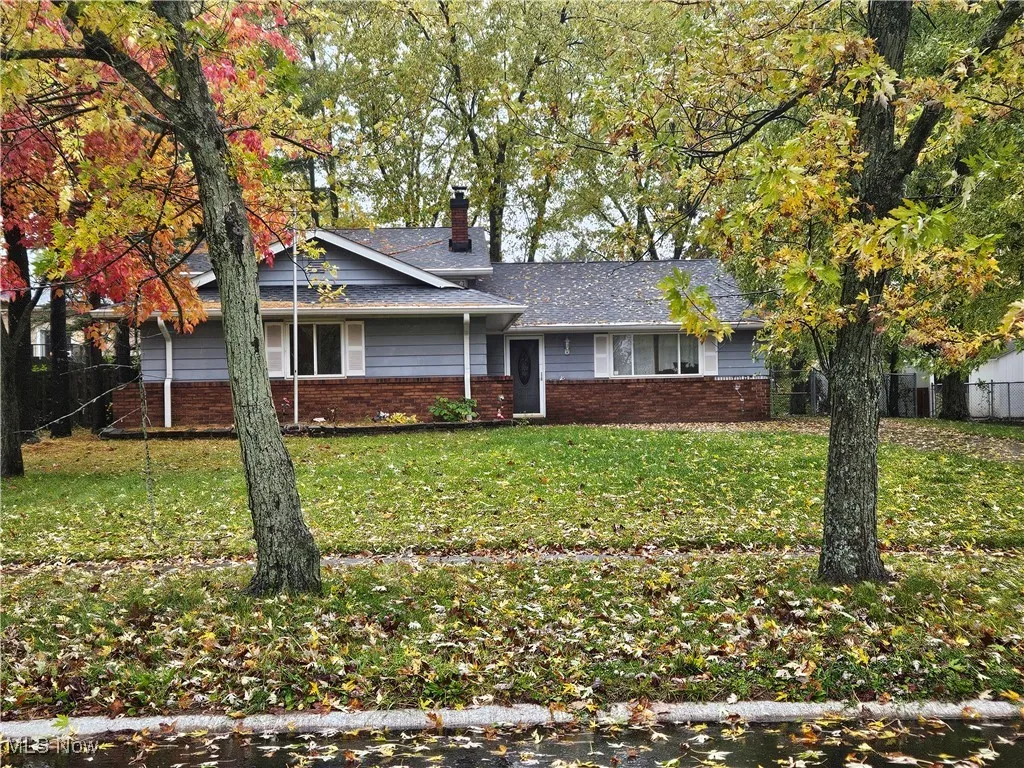 View of front of house featuring brick siding and a chimney