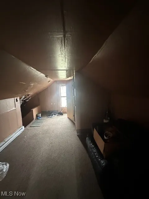 Bonus room with lofted ceiling, carpet, and a baseboard heating unit