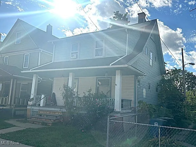 View of front of property featuring a chimney and a porch