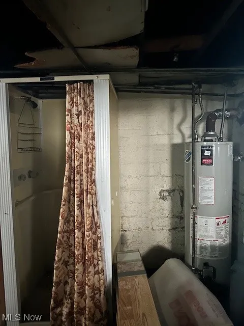 Unfinished below grade area featuring water heater