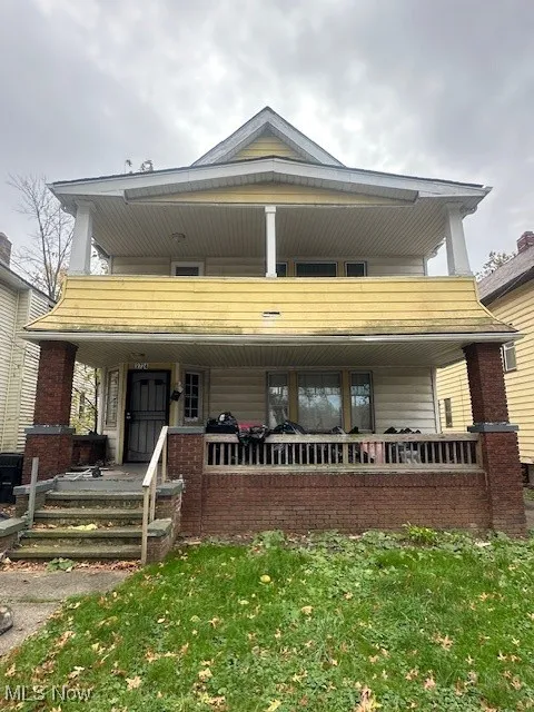 View of front facade featuring covered porch, a balcony, and a front yard