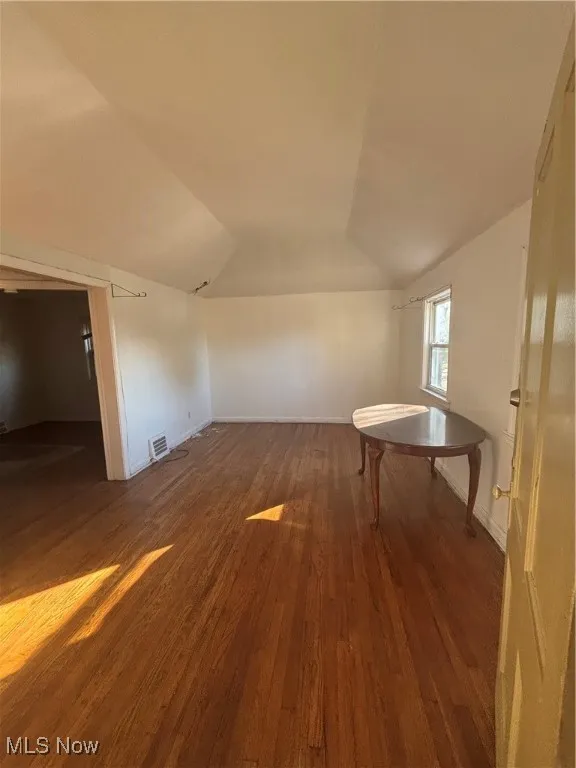 Bonus room featuring dark wood-style floors and lofted ceiling
