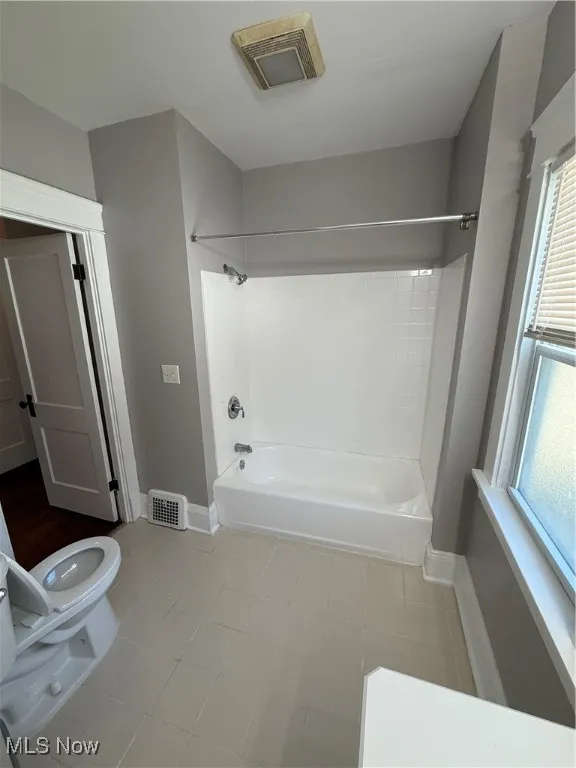 Full bath with shower / tub combination and light tile patterned flooring