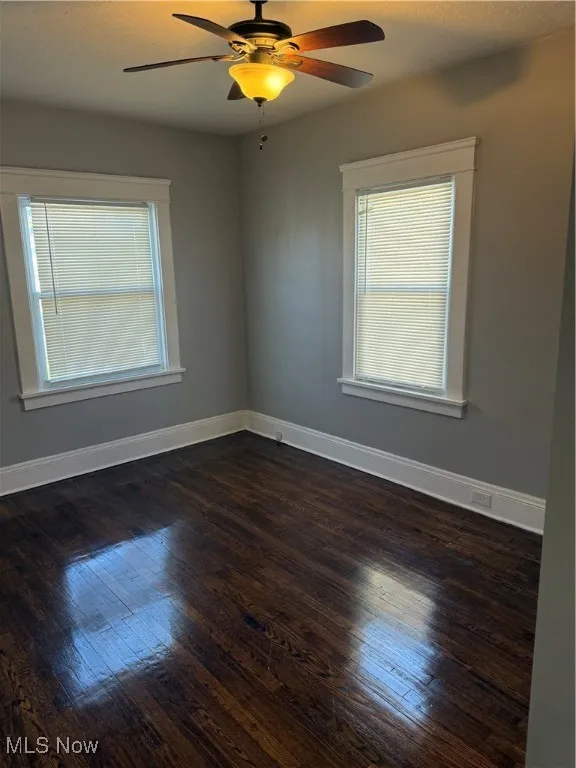 Unfurnished room featuring dark wood-style floors, ceiling fan, and a textured ceiling
