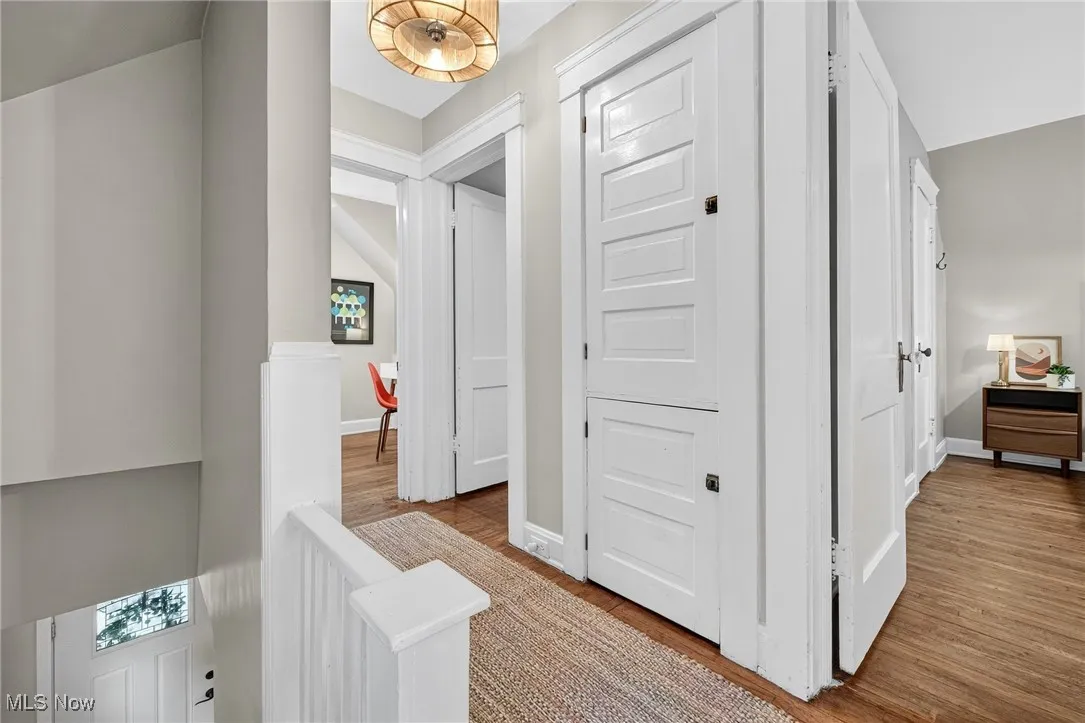 Hallway with an upstairs landing and light wood finished floors