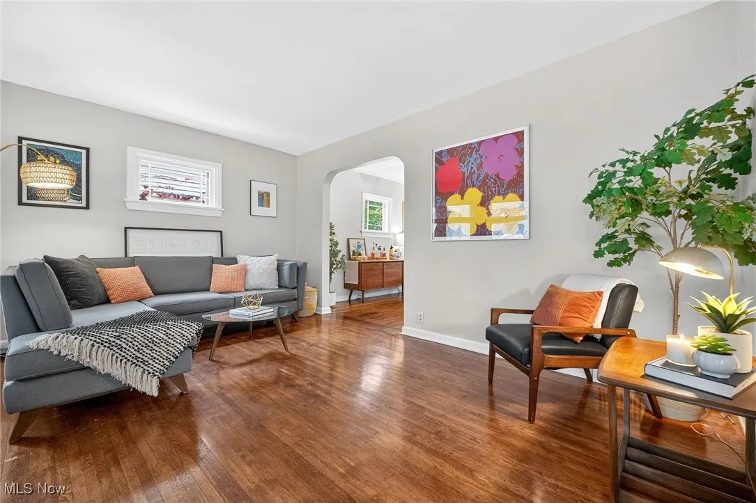 Living area with arched walkways and wood finished floors