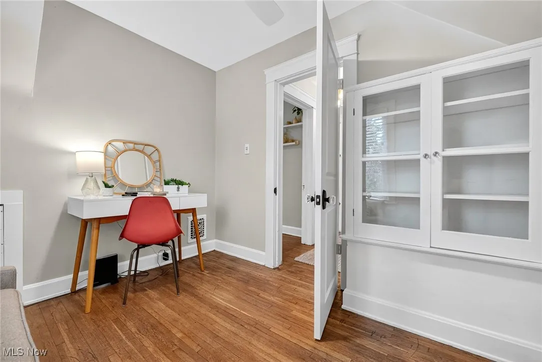 Home office with hardwood / wood-style floors and vaulted ceiling