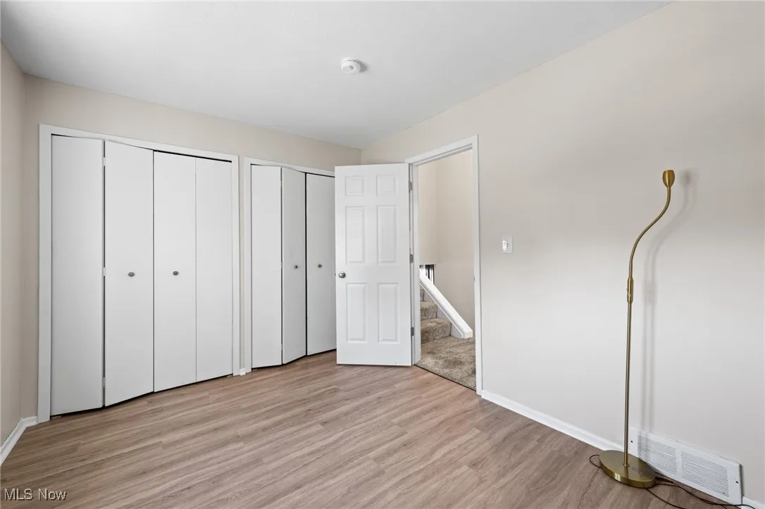bedroom featuring two closets and light wood finished floors