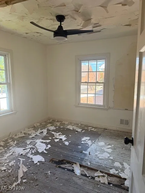 Empty room featuring hardwood / wood-style flooring and ceiling fan