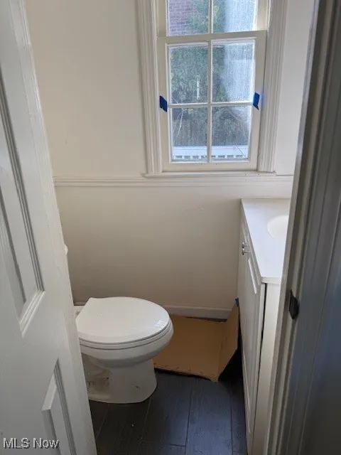 Half bathroom featuring vanity and dark wood finished floors