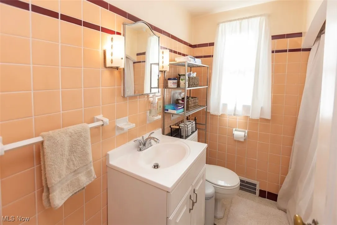 Down unit Bathroom with vanity, tile walls, and curtained shower