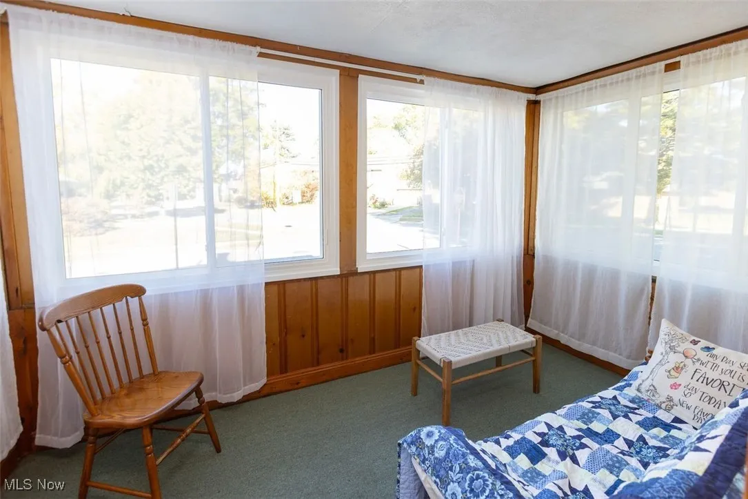 Down unit Sunroom featuring carpet and baseboards