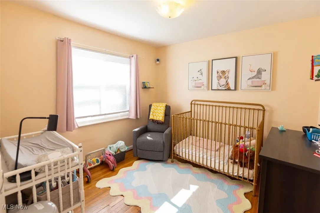 Down unit Bedroom 2 featuring a nursery area and wood-type flooring