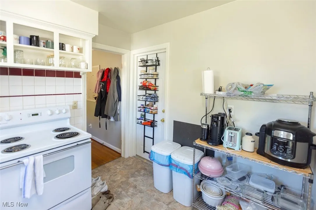 Up unit Kitchen featuring white range with electric stovetop and open shelves