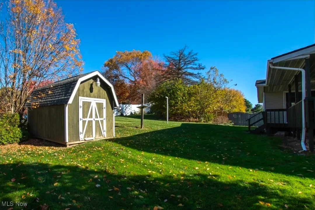 View of grassy yard featuring a storage shed