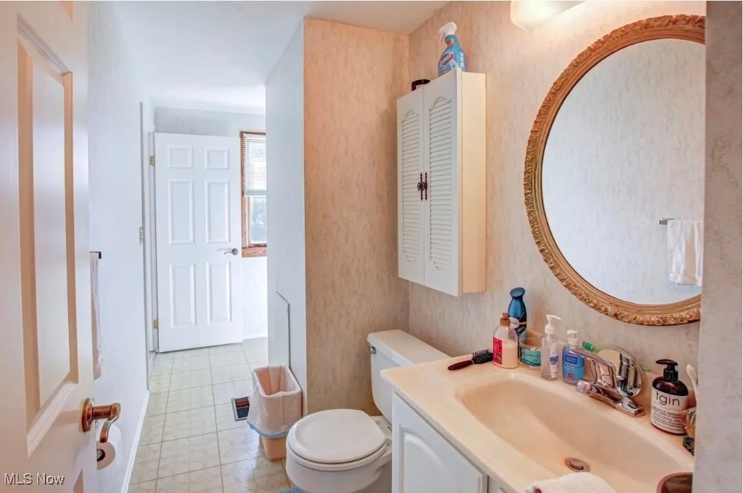 Full bath with vanity and wallpapered walls