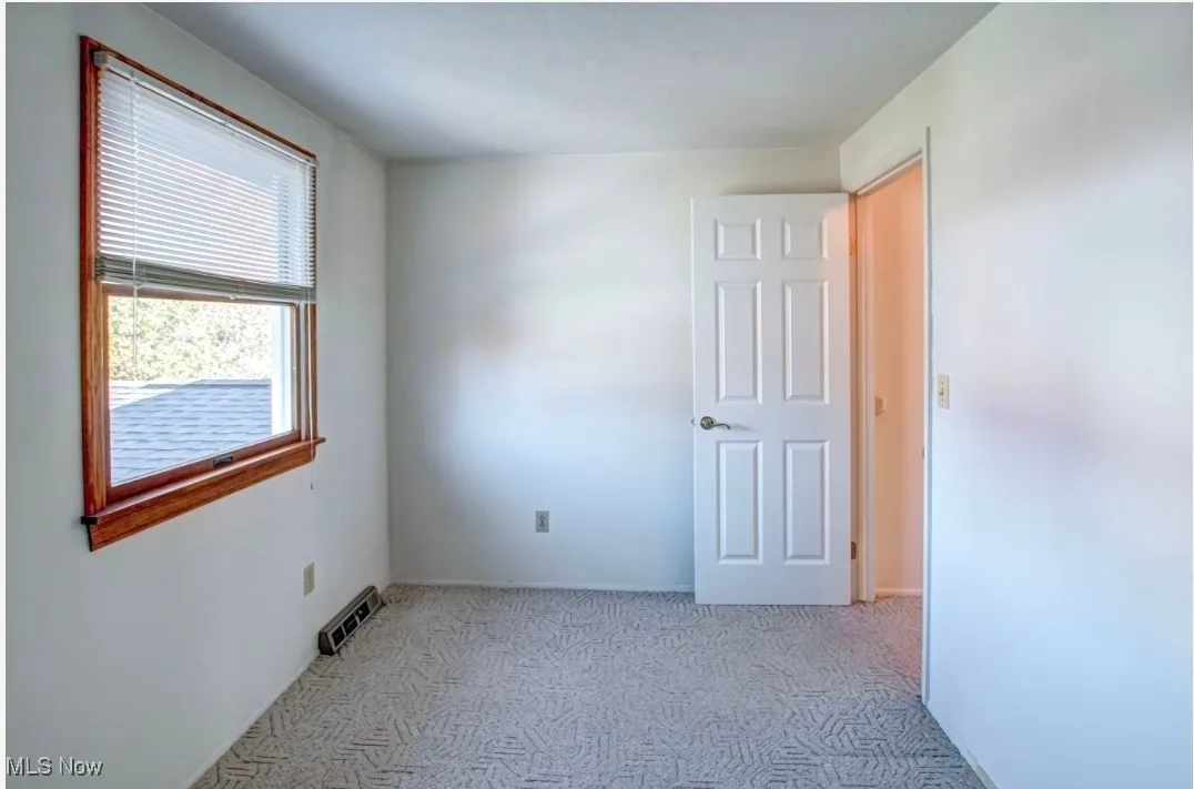 Unfurnished room with light colored carpet and baseboards