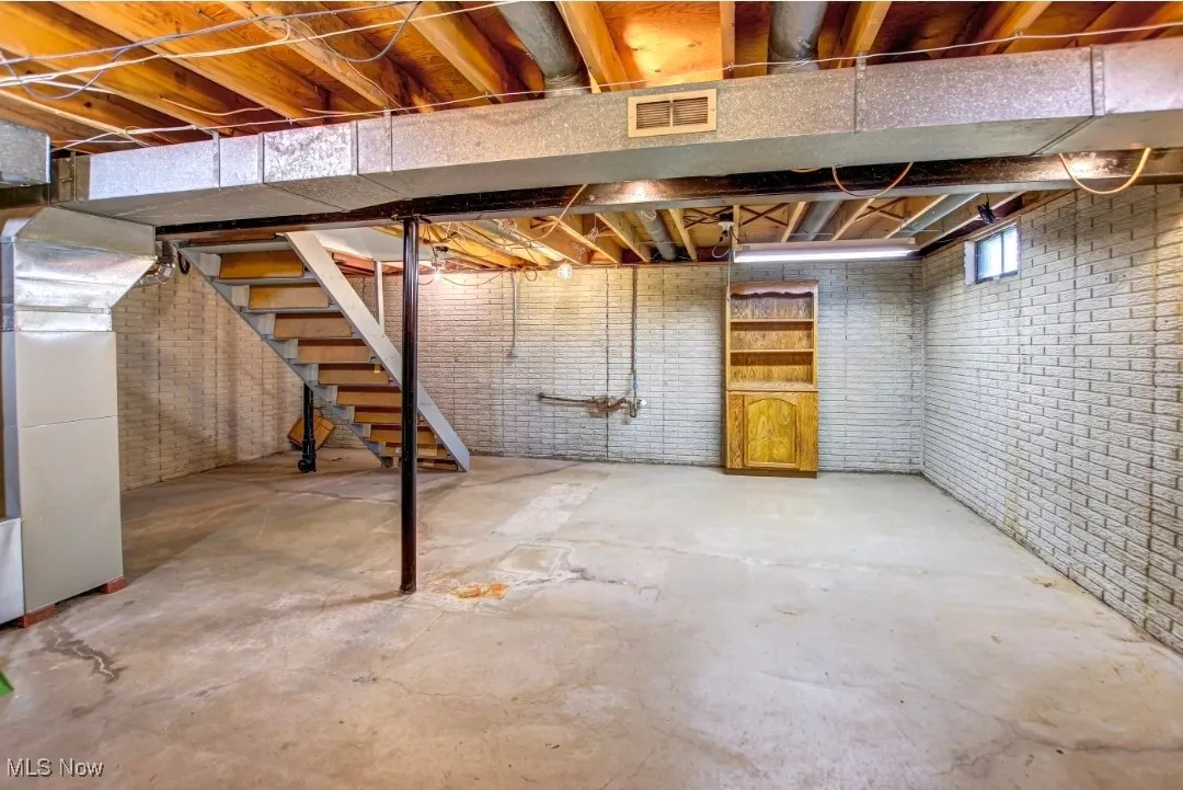 Below grade area with stairs and heating unit