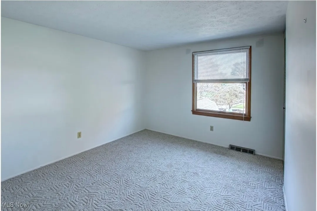 Unfurnished room with carpet floors and a textured ceiling
