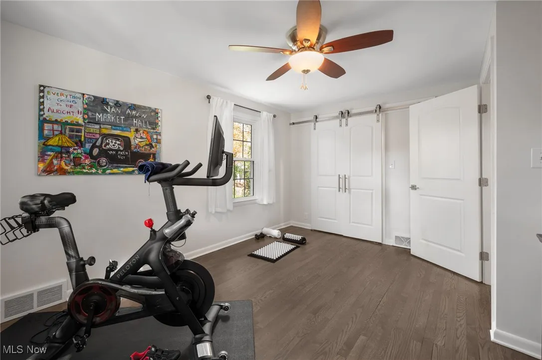 Bedroom #4, now used as an exercise room, also incorporates a farm door, closet built-ins and real wood flooring.