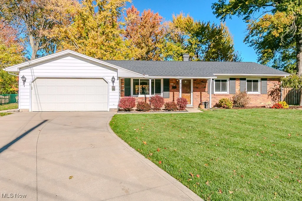 Ranch-style home featuring covered porch, brick siding, a chimney, and concrete driveway