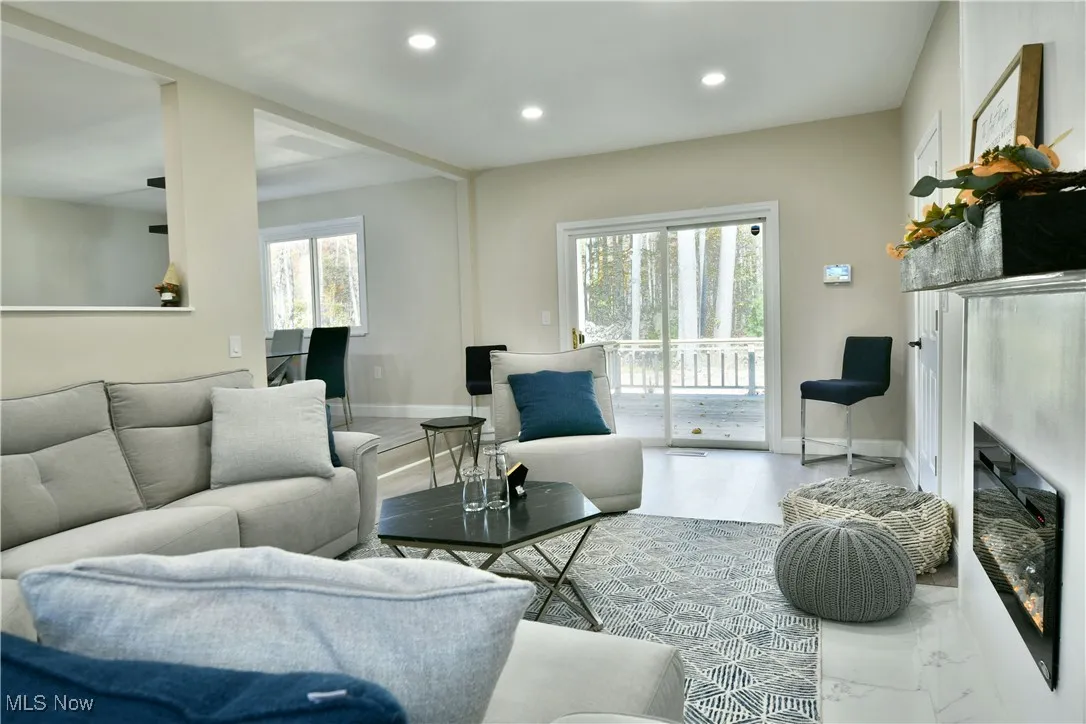 Living room with a glass covered fireplace and recessed lighting