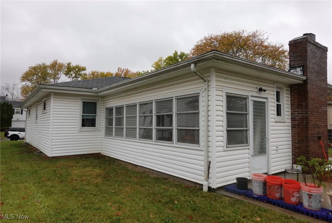 View of home's exterior featuring a lawn and a chimney