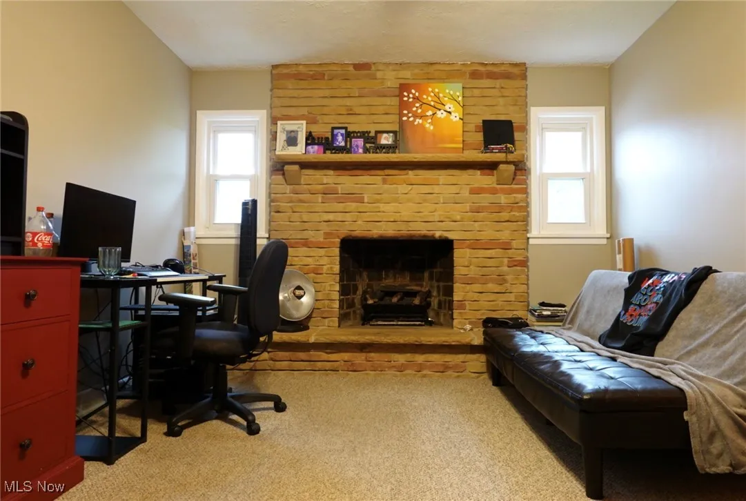 Office area with plenty of natural light, a brick fireplace, and light colored carpet
