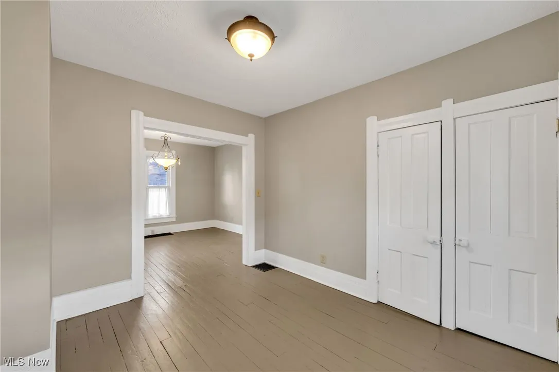 Spare room featuring hardwood / wood-style flooring and a chandelier