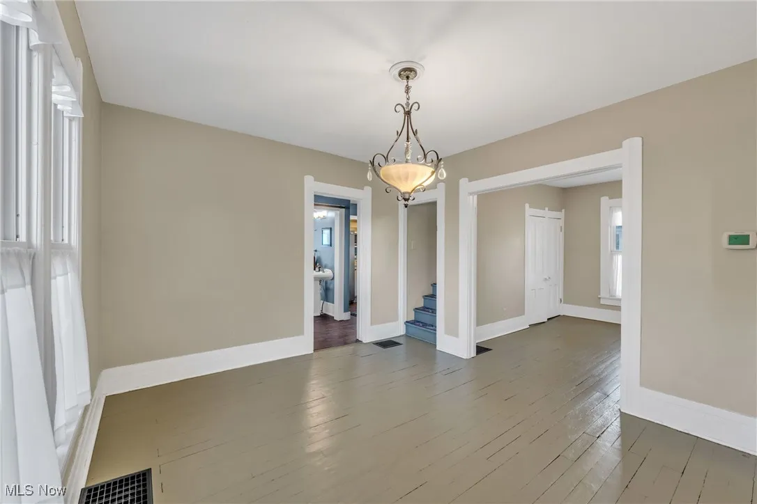 Unfurnished dining area with wood-type flooring and stairs