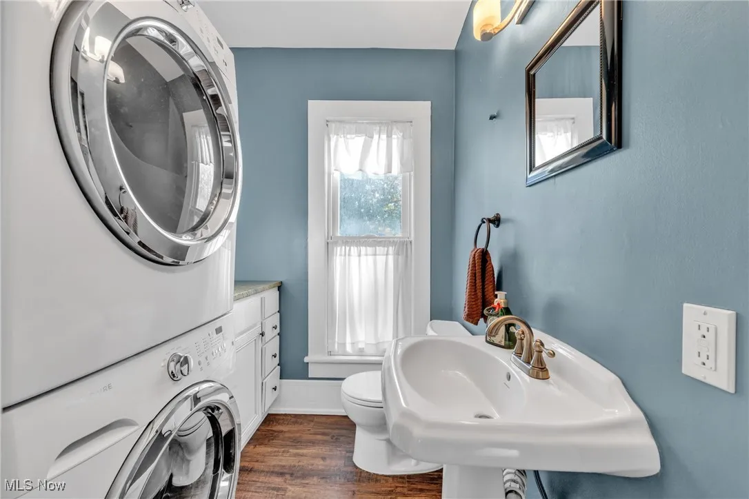 Bathroom featuring estacked washer and dryer and dark wood-style flooring