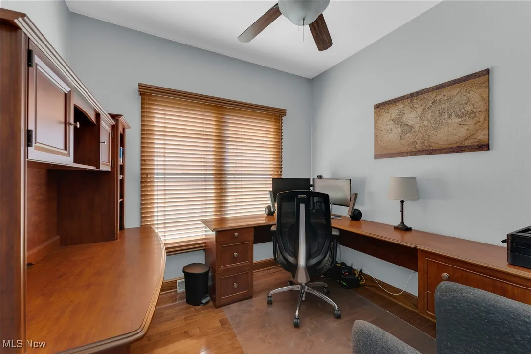 Office space featuring light wood-type flooring, ceiling fan, and built in study area