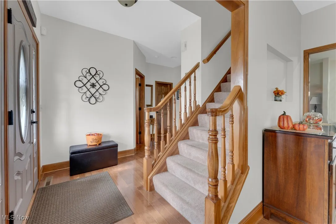 Entrance foyer with wood finished floors and stairway