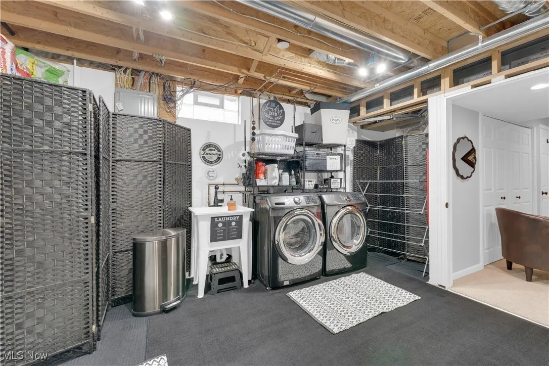 Washroom with washer and clothes dryer and carpet flooring