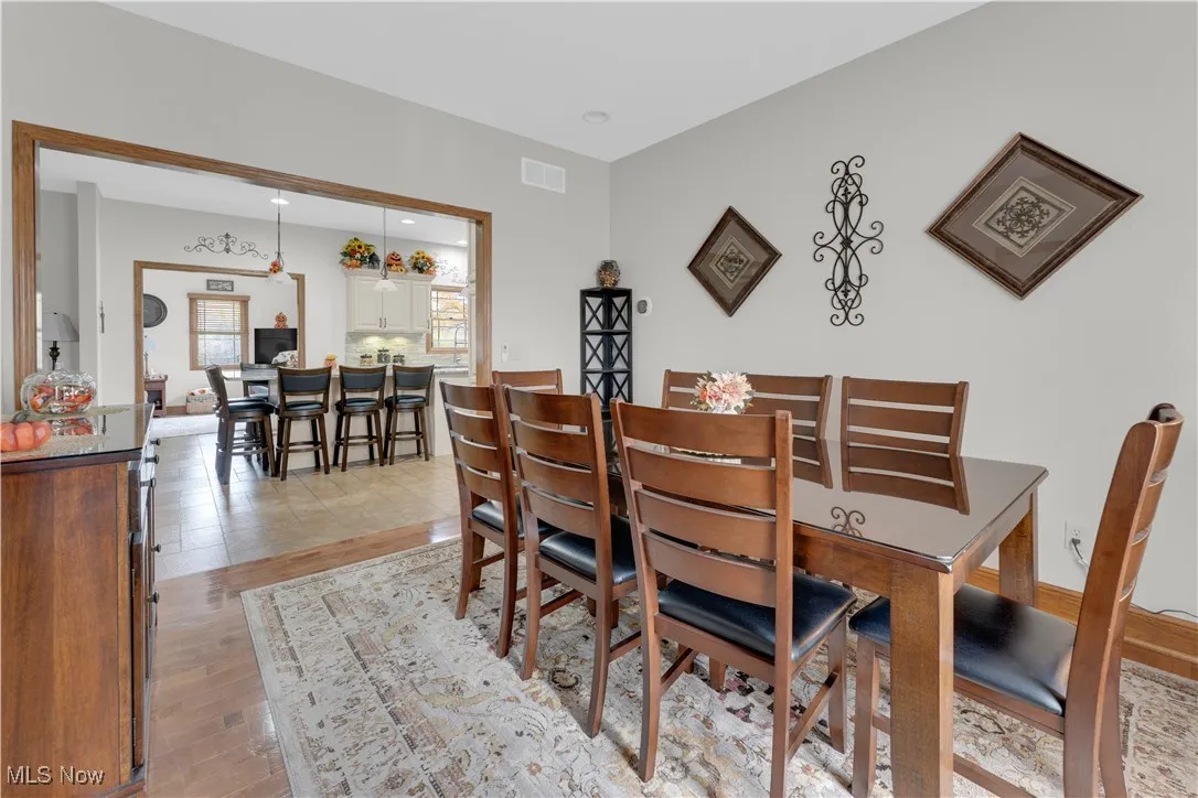 Dining area with light wood finished floors and recessed lighting