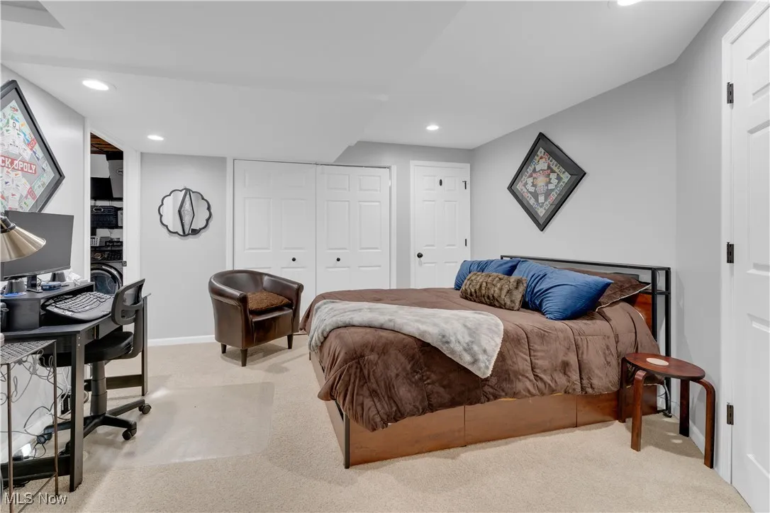 Carpeted bedroom with an office area, recessed lighting, and a closet