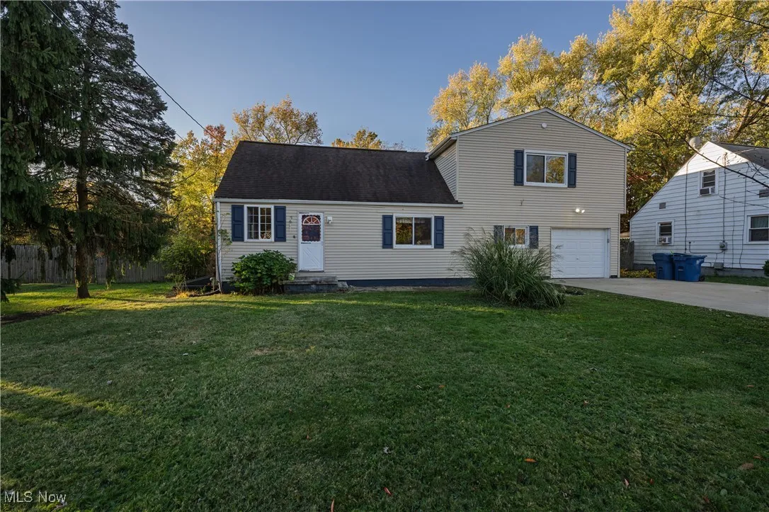 Traditional-style house with concrete driveway, a front lawn, and a garage