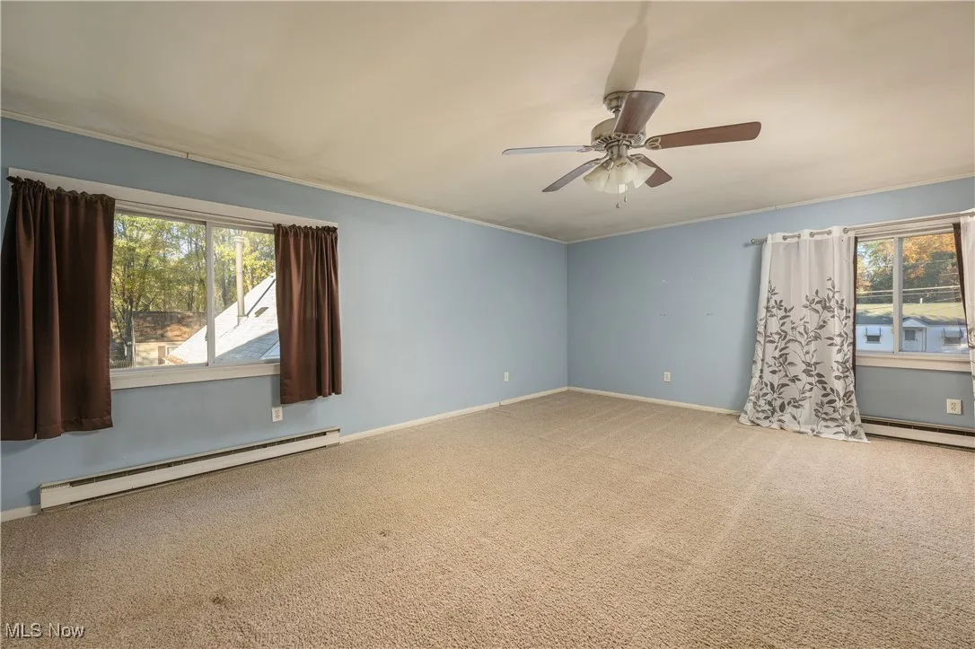 Unfurnished room with a baseboard radiator, carpet flooring, and ornamental molding