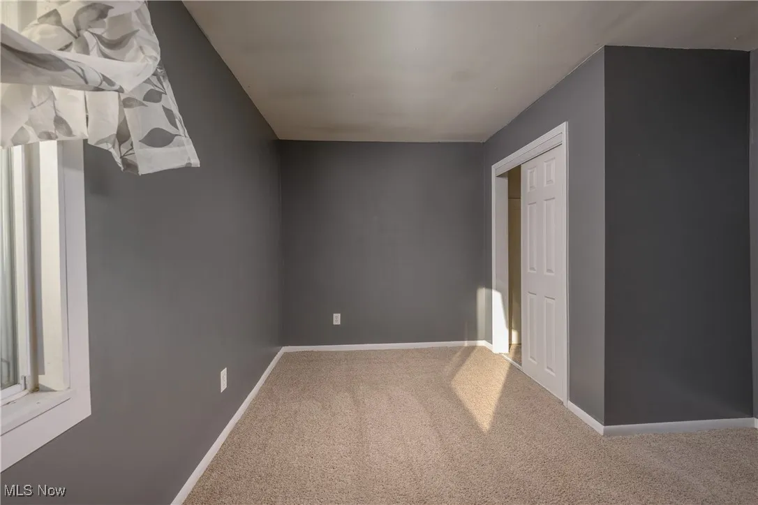 Unfurnished bedroom featuring carpet floors and baseboards