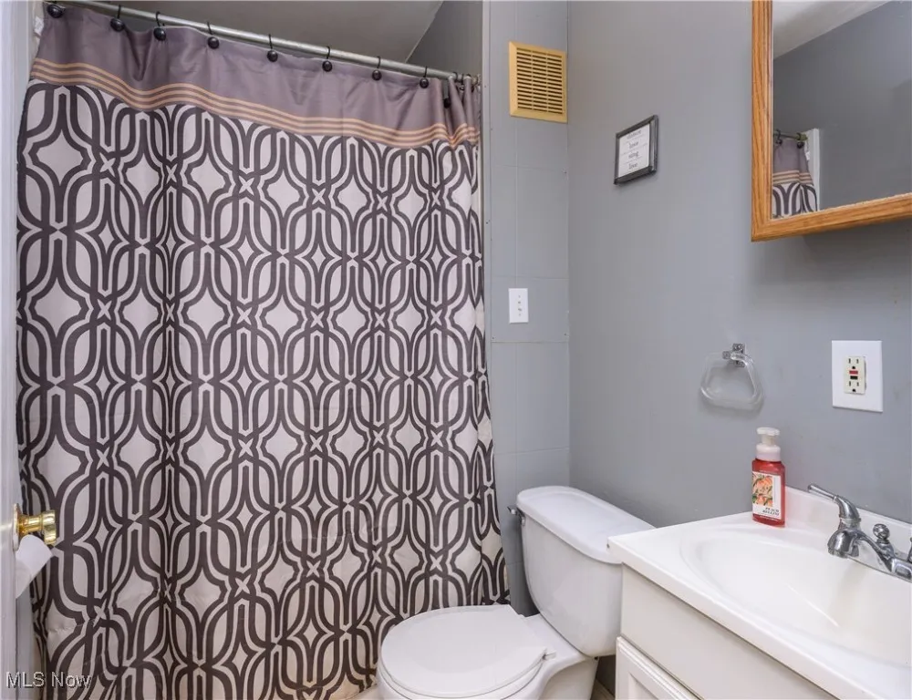 Bathroom with vanity and curtained shower