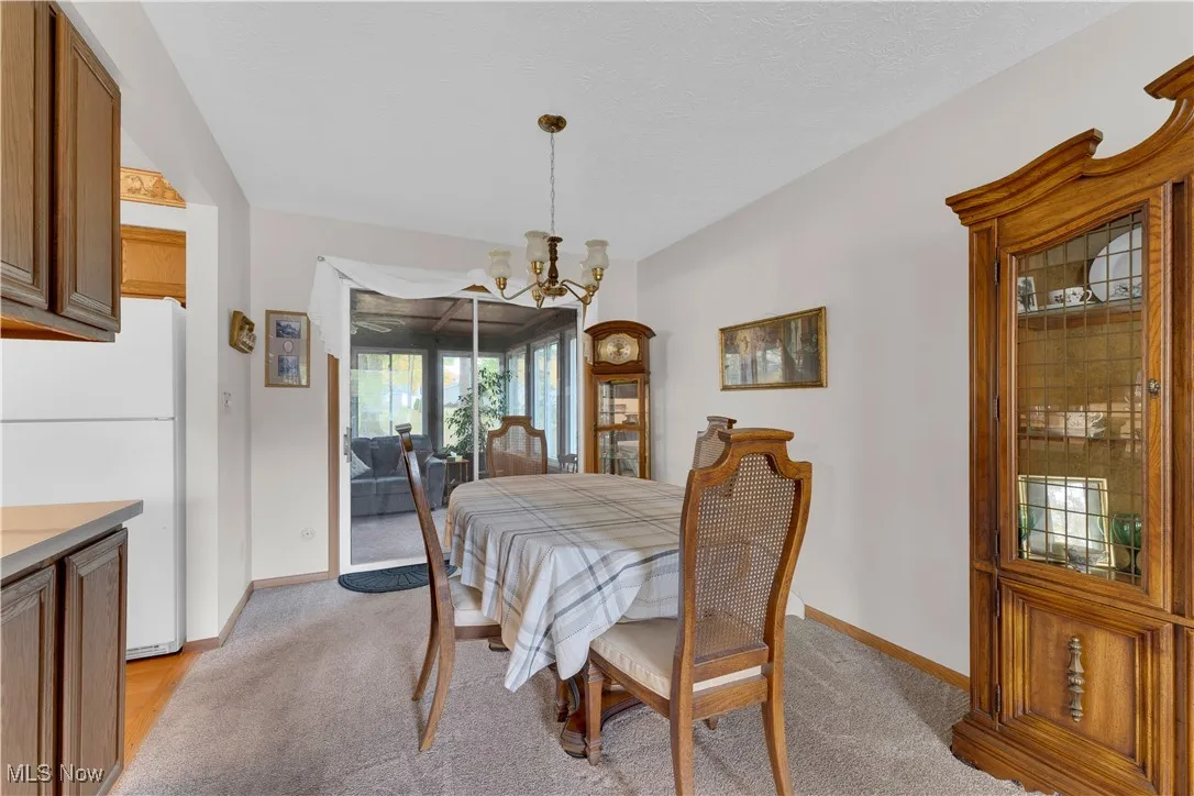 Dining area with a chandelier and light colored carpet