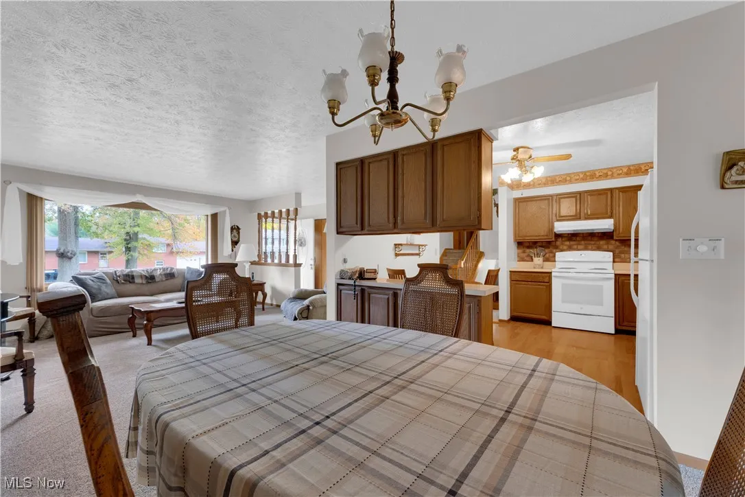 Bedroom featuring a textured ceiling, a chandelier, and freestanding refrigerator