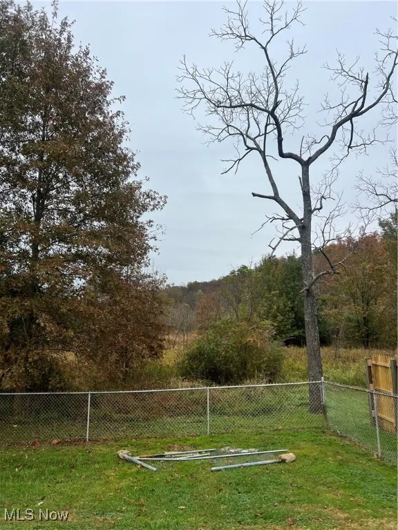 Fenced in back yard with a wooded view