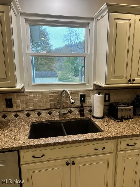 Kitchen with light stone counters and decorative backsplash and private view