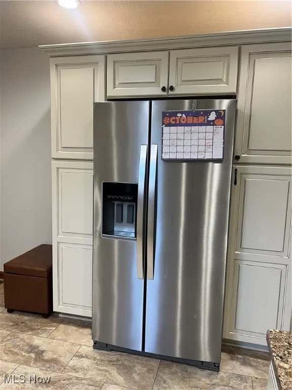 Kitchen view of stainless steel fridge with ice dispenser and gray cabinetry