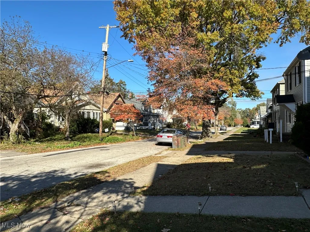 View of asphalt street featuring a residential view, sidewalks, and street lighting