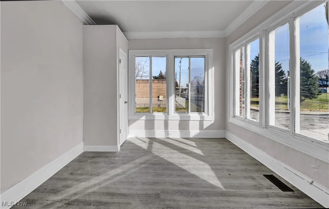 Empty room featuring crown molding and light wood-style floors
